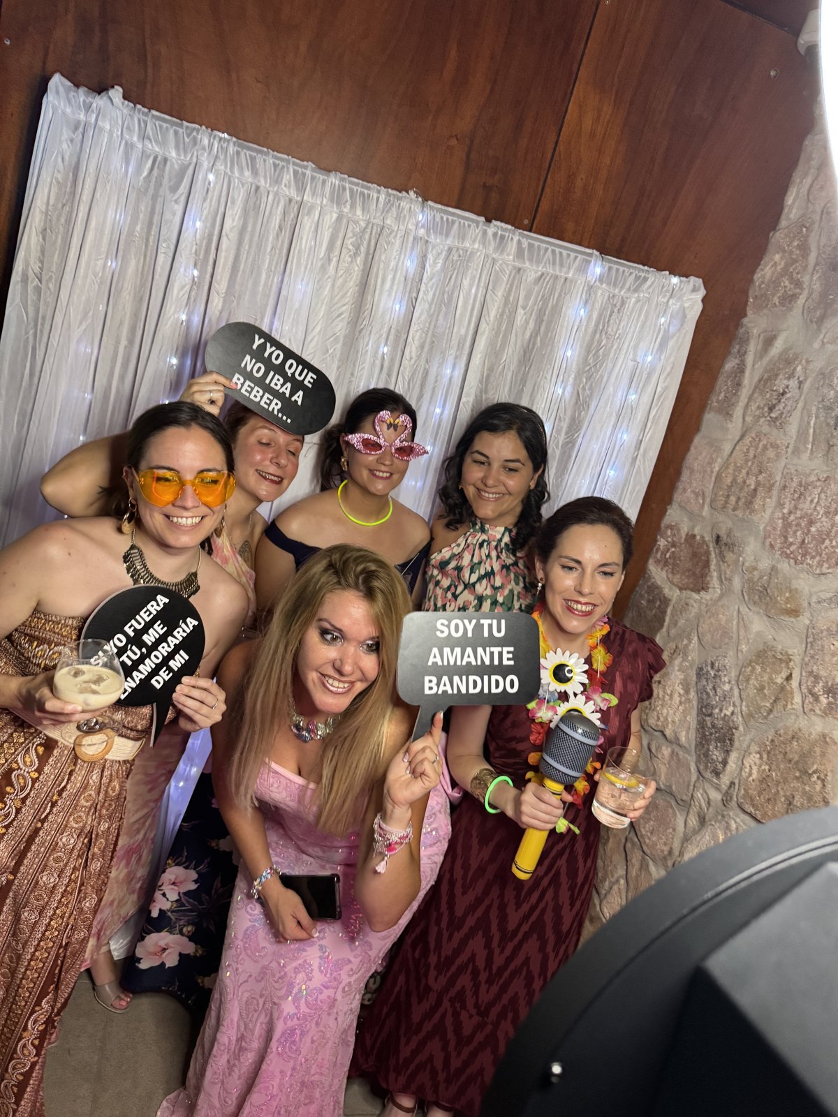 Invitadas sonriendo con accesorios en el fotomatón